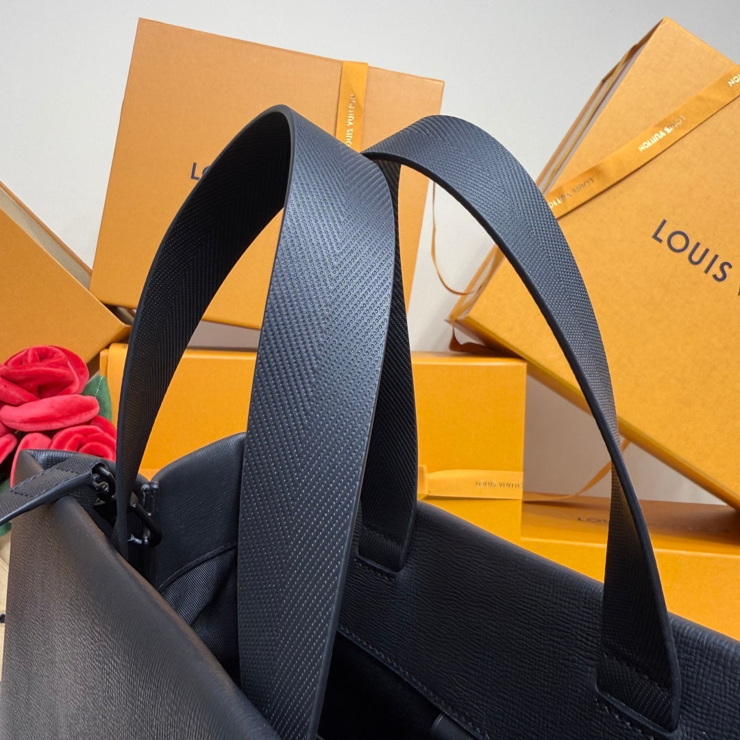 Navy Louis Vuitton tote bag showing textured leather strap and side panel