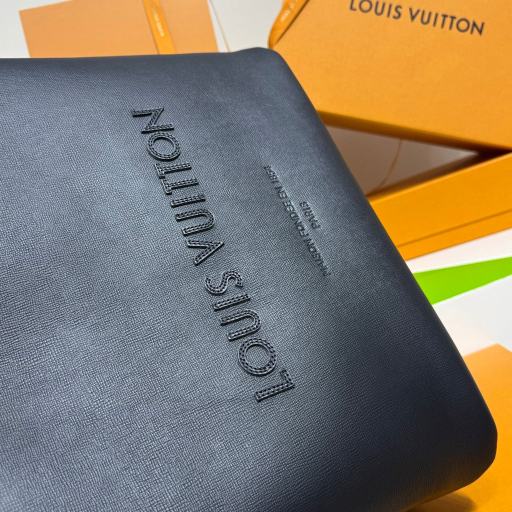 Navy Louis Vuitton bag with vertical embossed “Louis Vuitton” lettering detail