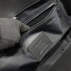 Louis Vuitton bag interior leather tag and zipper close-up in dark gray.