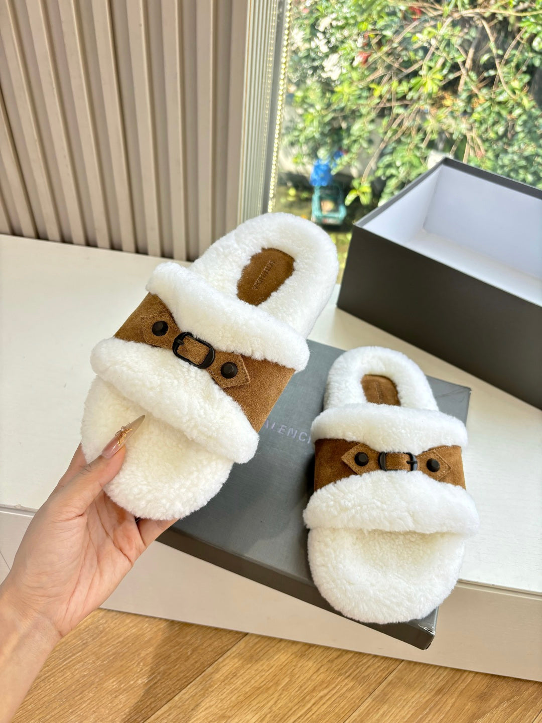Balenciaga shearling slide sandals, white plush slides with brown suede strap; hand hold