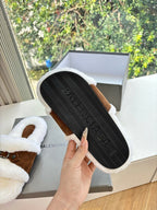 Women's sherpa slide sandals, view of black rubber outsole with tread