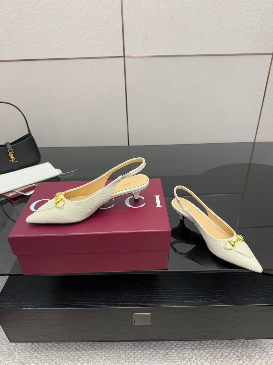 Cream slingback pumps with gold horsebit buckle detail and low heel