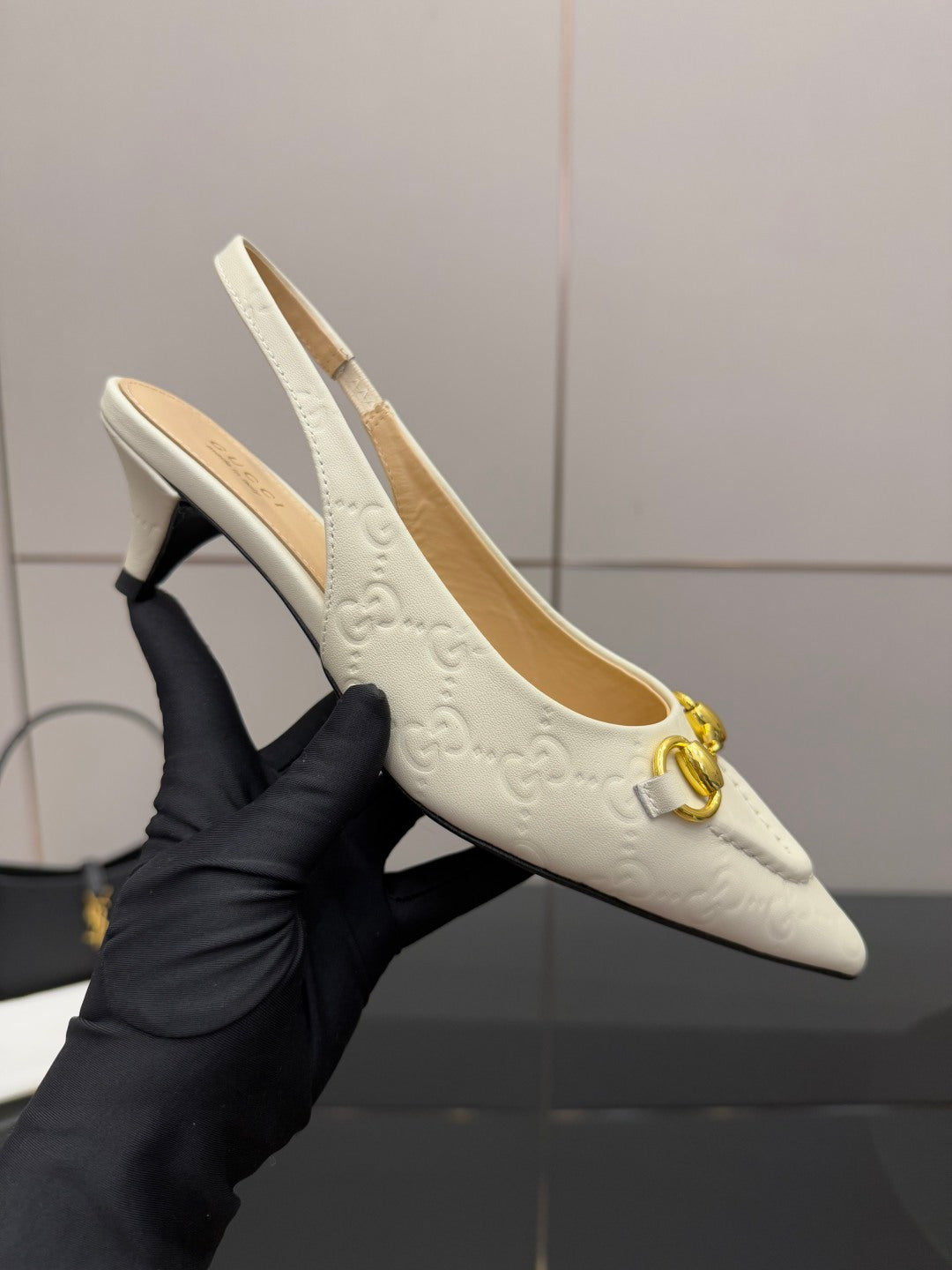 Cream high-heel slingback with gold horsebit and embossed texture