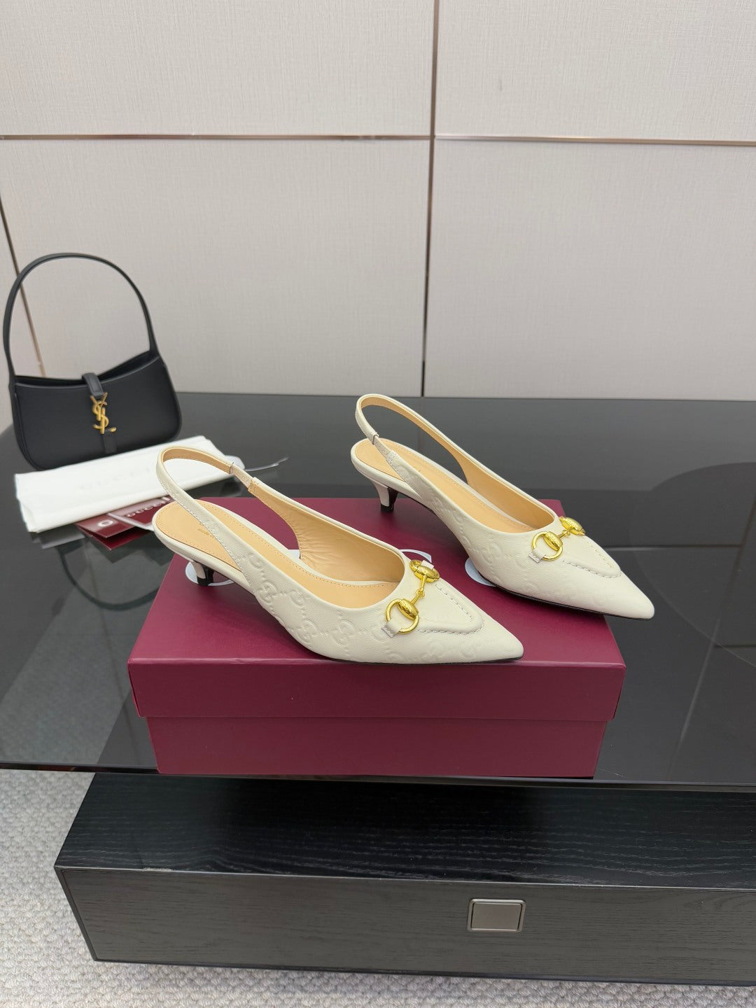 Cream pointed-toe slingback pumps with gold horsebit and mid heel