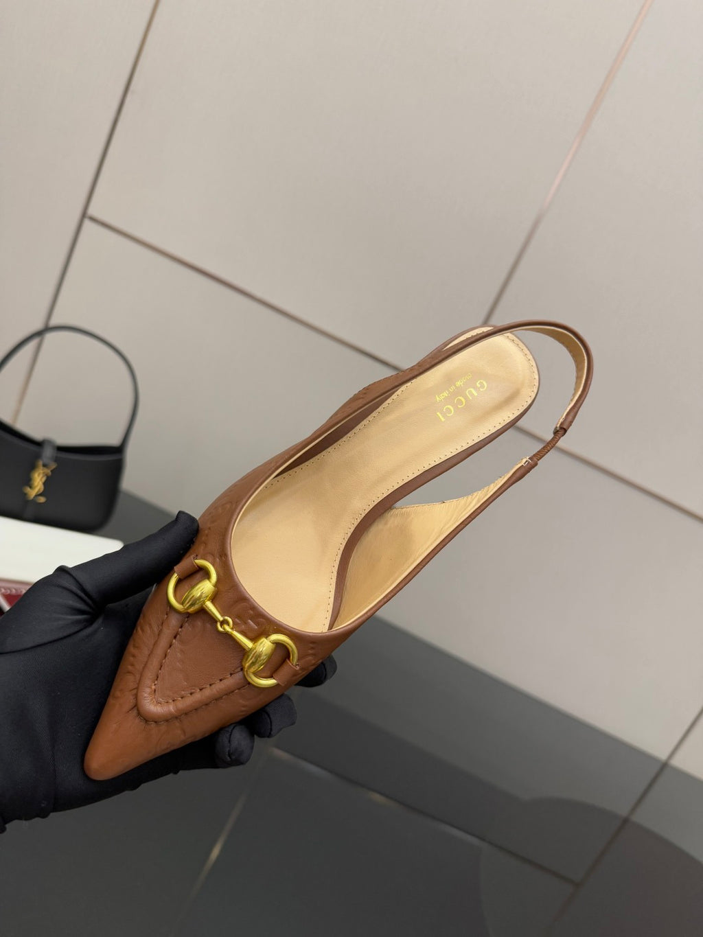Brown slingback heel close-up with gold-tone ring strap detail and open back