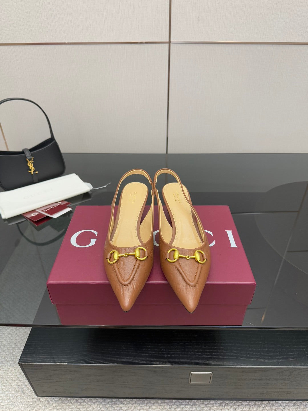 Brown leather slingback heels with gold-tone buckle detail, pointed toe