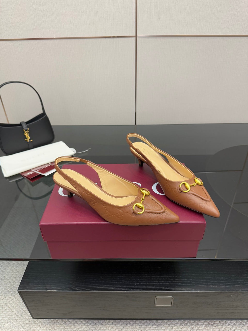 Pair of brown slingback heels with gold ring buckle detail and pointed toe