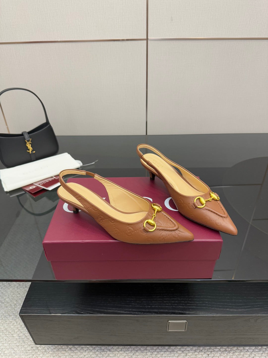 Pair of brown slingback heels with gold ring buckle detail and pointed toe
