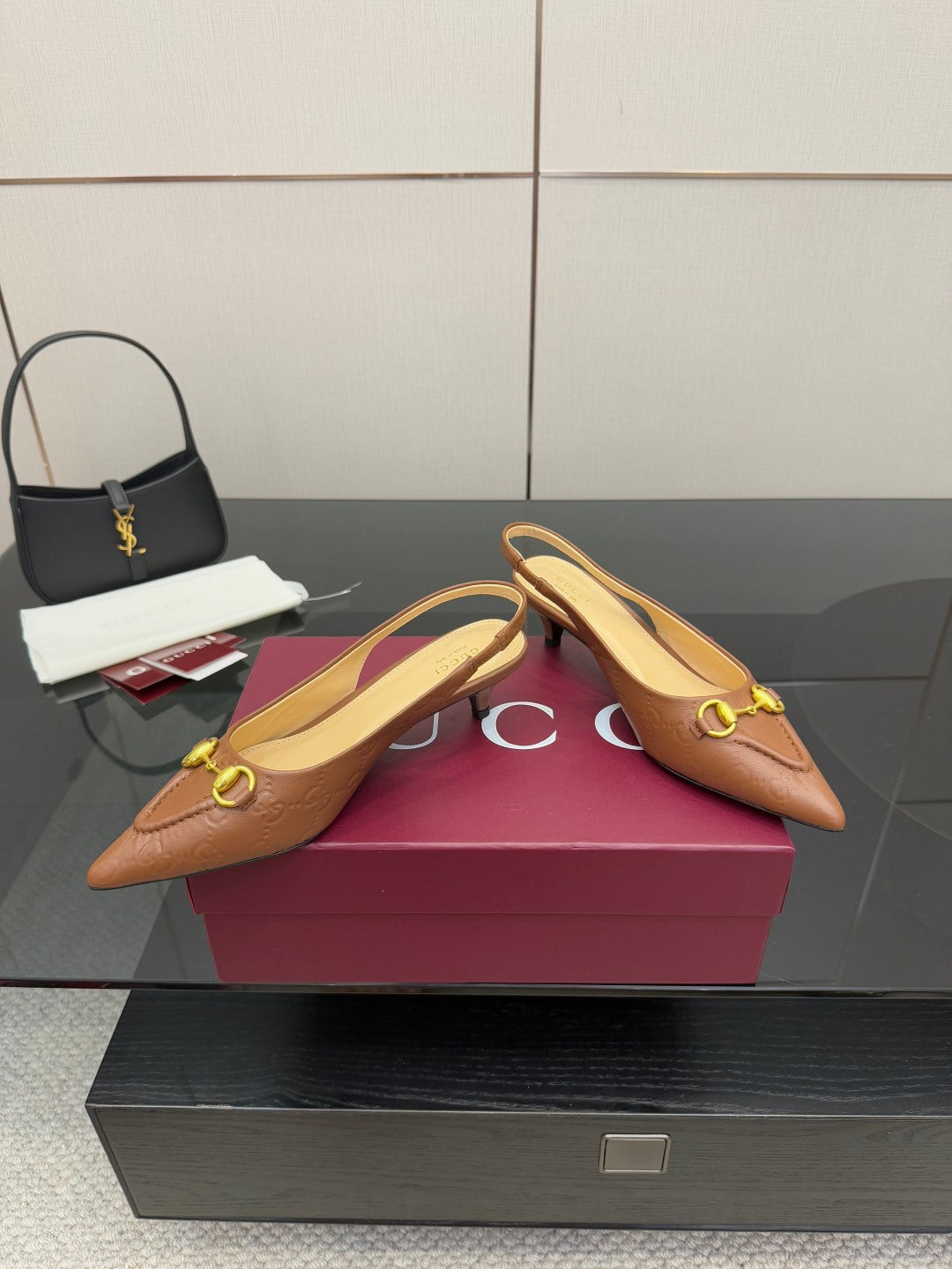 Brown slingback heels displayed on box, gold hardware and pointed toe