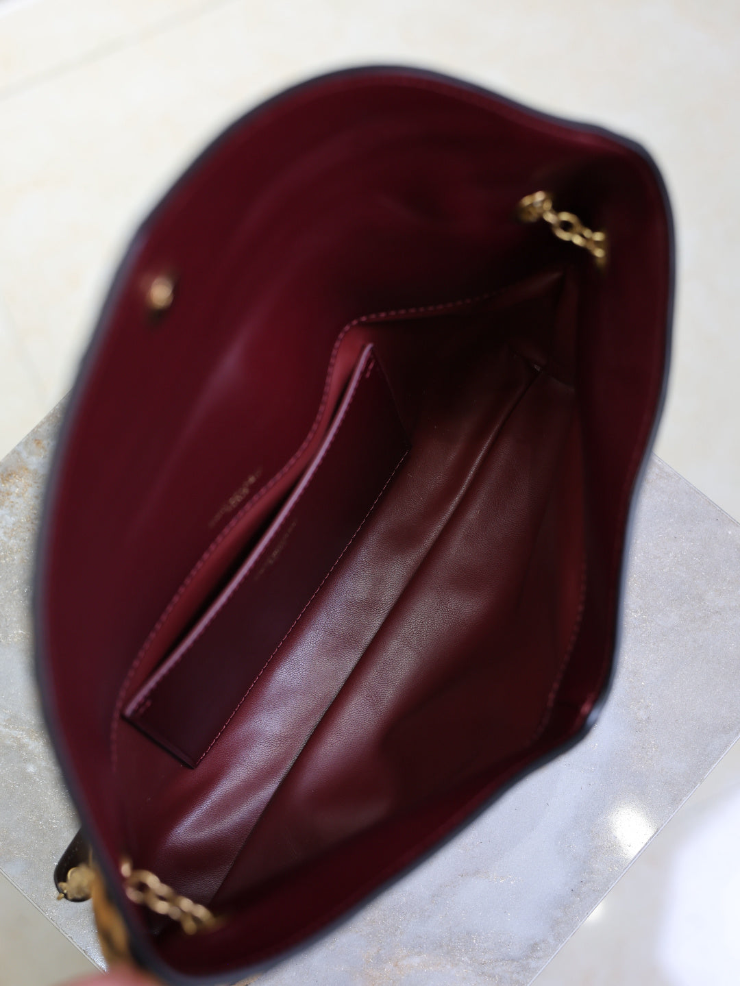 YSL burgundy leather-style shoulder bag interior with gold chain detail