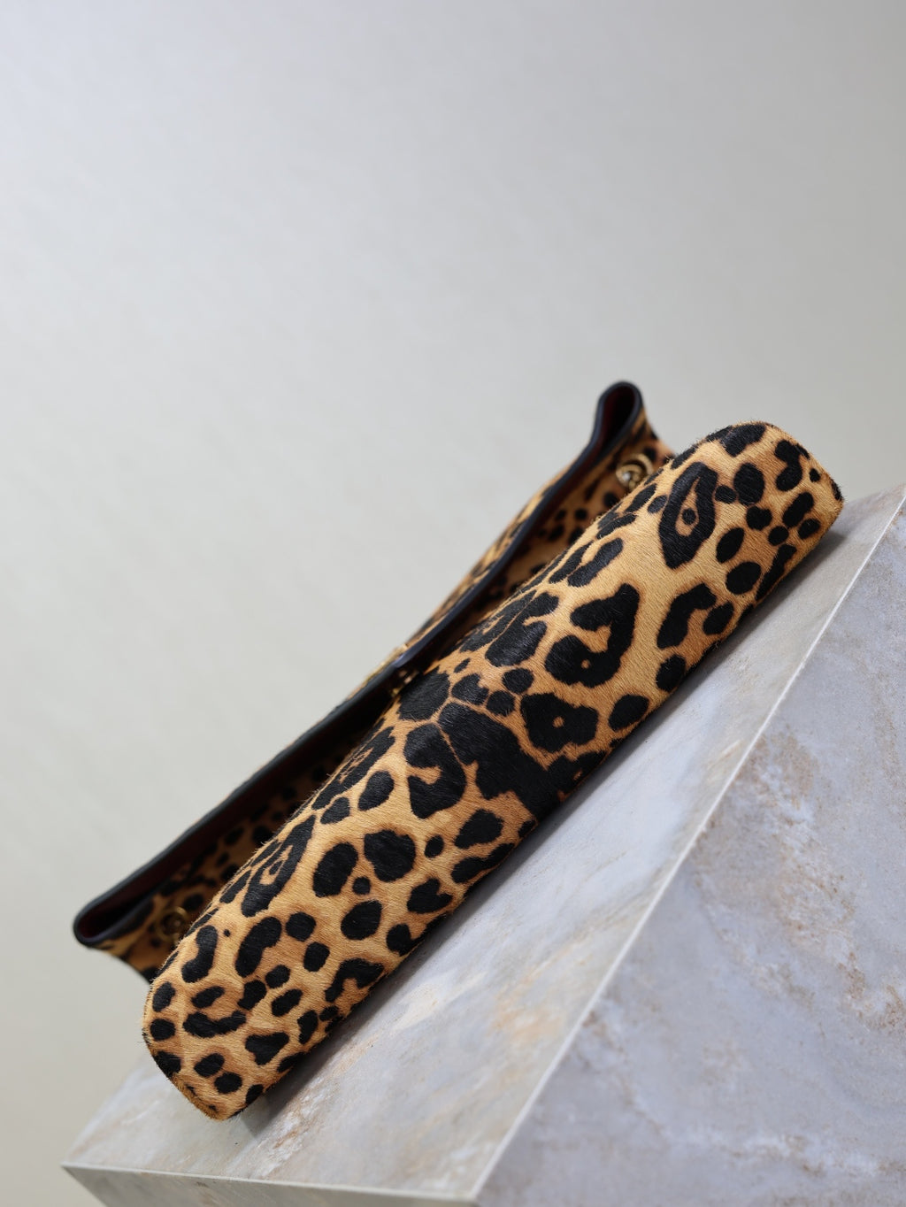 YSL leopard-print shoulder bag lying on display with flap opening