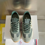 Moncler sneakers standing side-by-side in sage and dark green with lace-up design