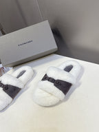 Pair of faux shearling slide sandals with dark buckled strap, white