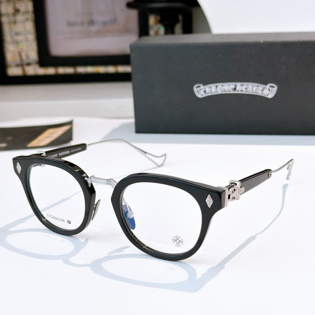 Black round-frame glasses with clear lenses and metal temples, with small logo detail.