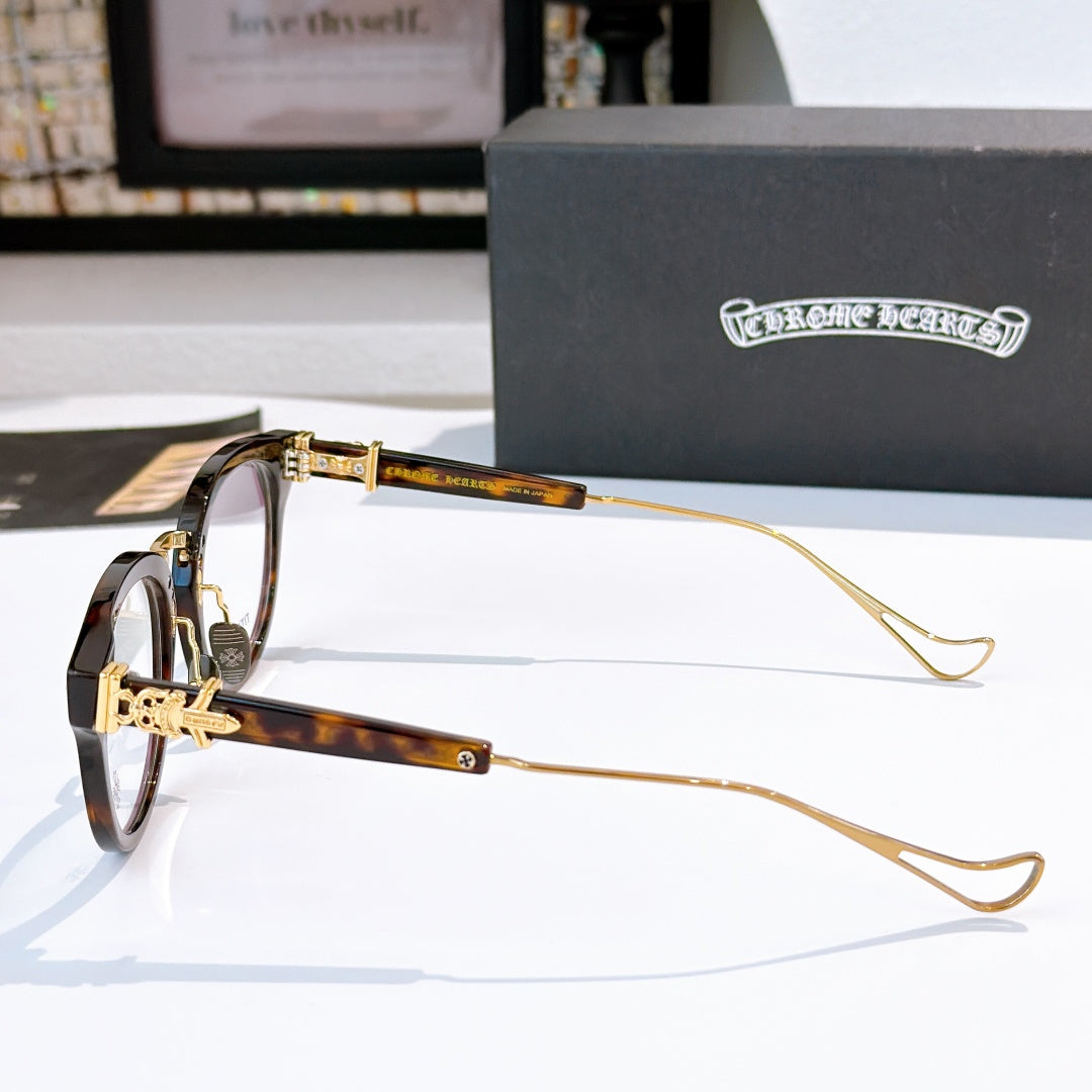 Tortoiseshell and gold glasses with thin gold temples and clear lenses; logo near hinge.