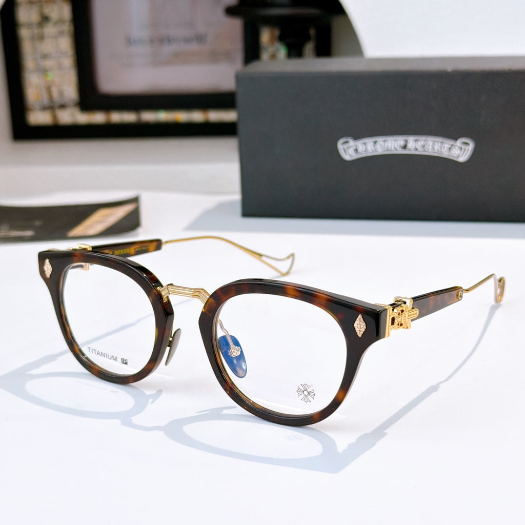 Brown tortoiseshell and gold round-frame glasses with clear lenses; logo at temple.