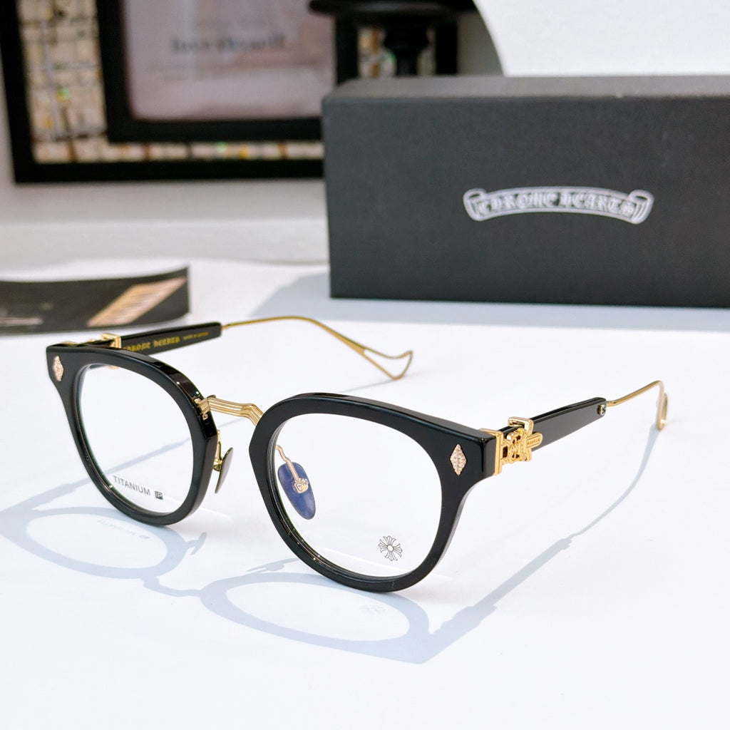 Black and gold cat-eye glasses with clear lenses and gold-tone temples; logo on front.