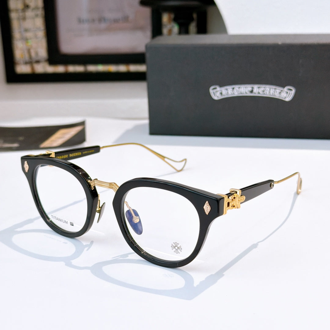 Black and gold cat-eye glasses with clear lenses and gold-tone temples; logo on front.