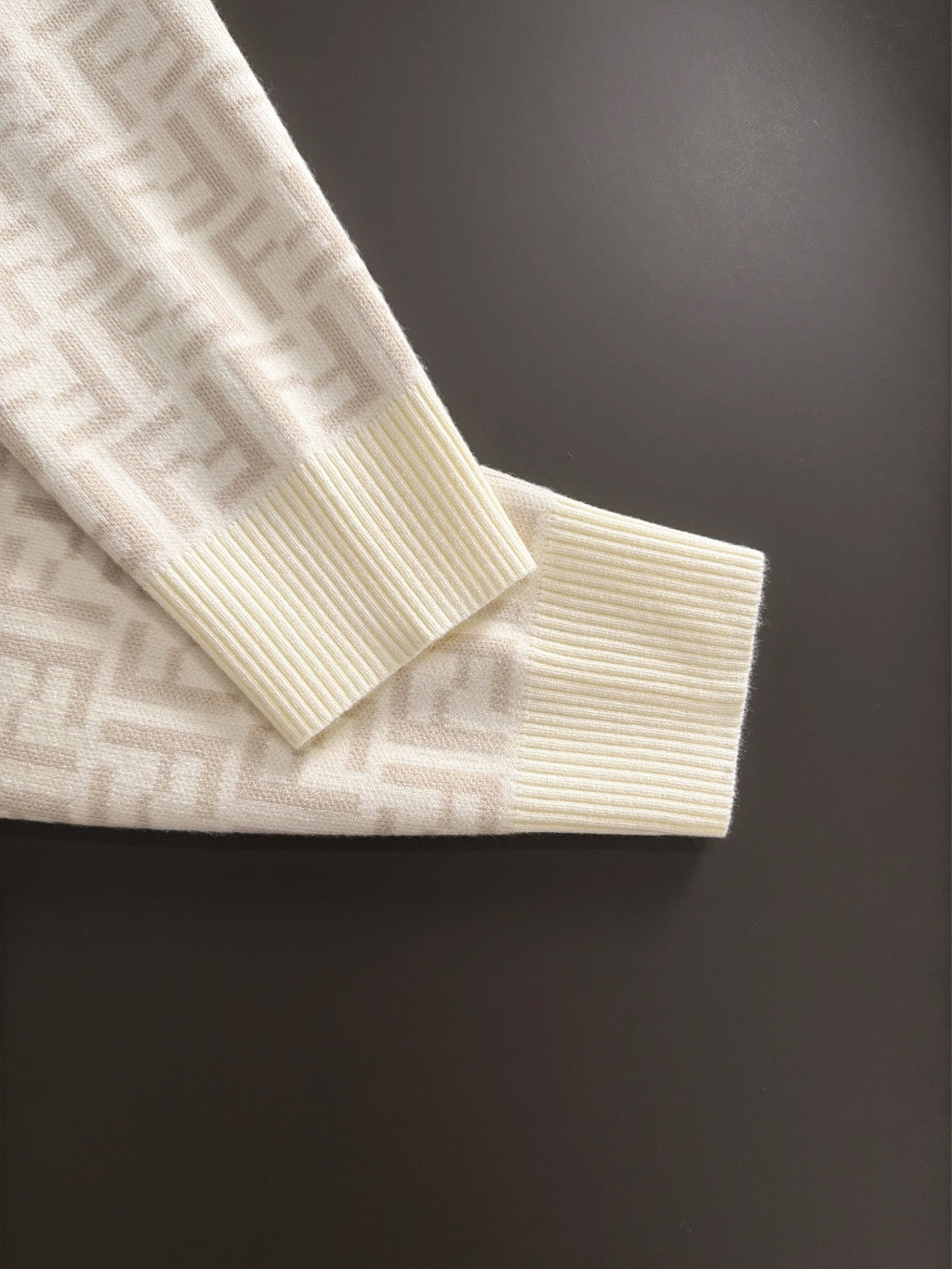 Cream sweater hem with ribbed knit edge and subtle Fendi FF pattern