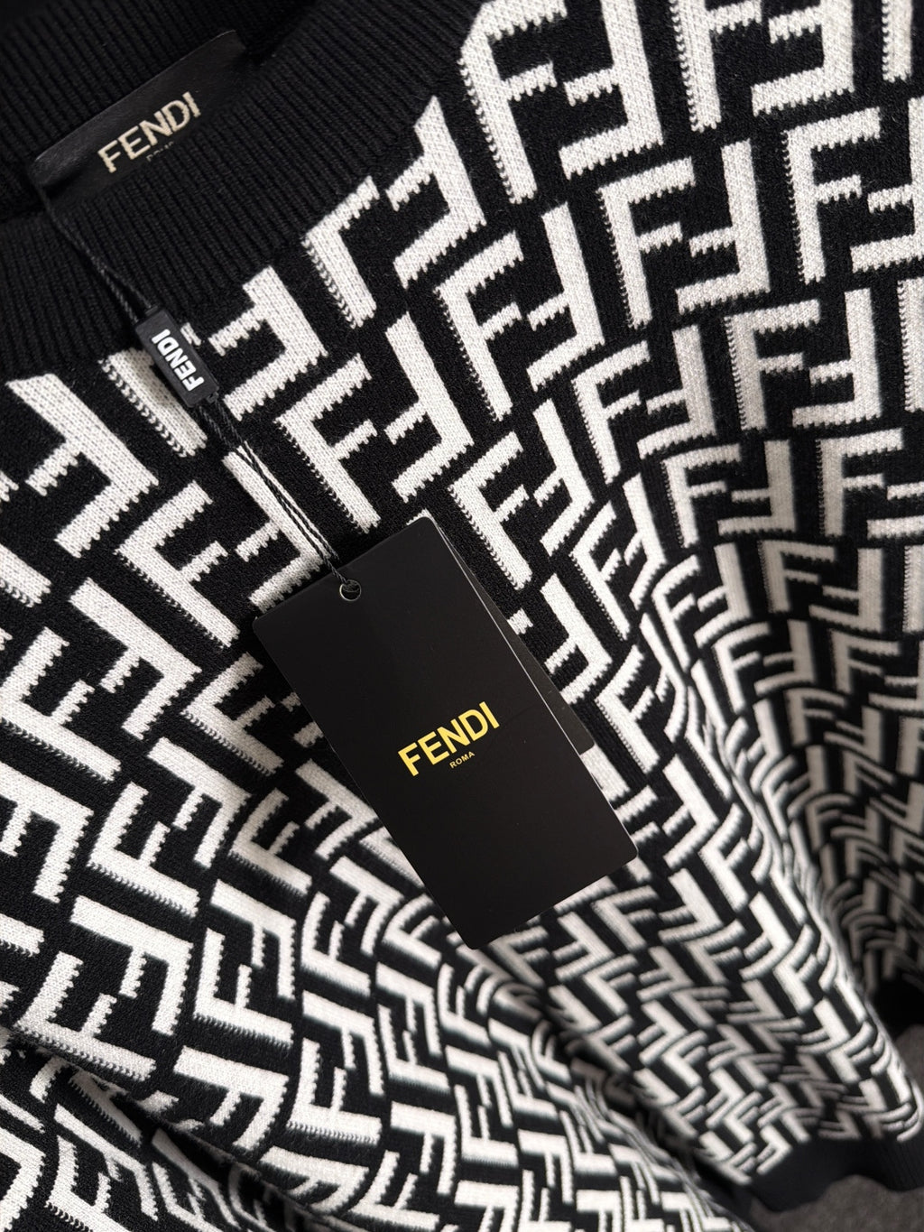 Fendi long-sleeve knit top front close-up, black with white FF logo and tag
