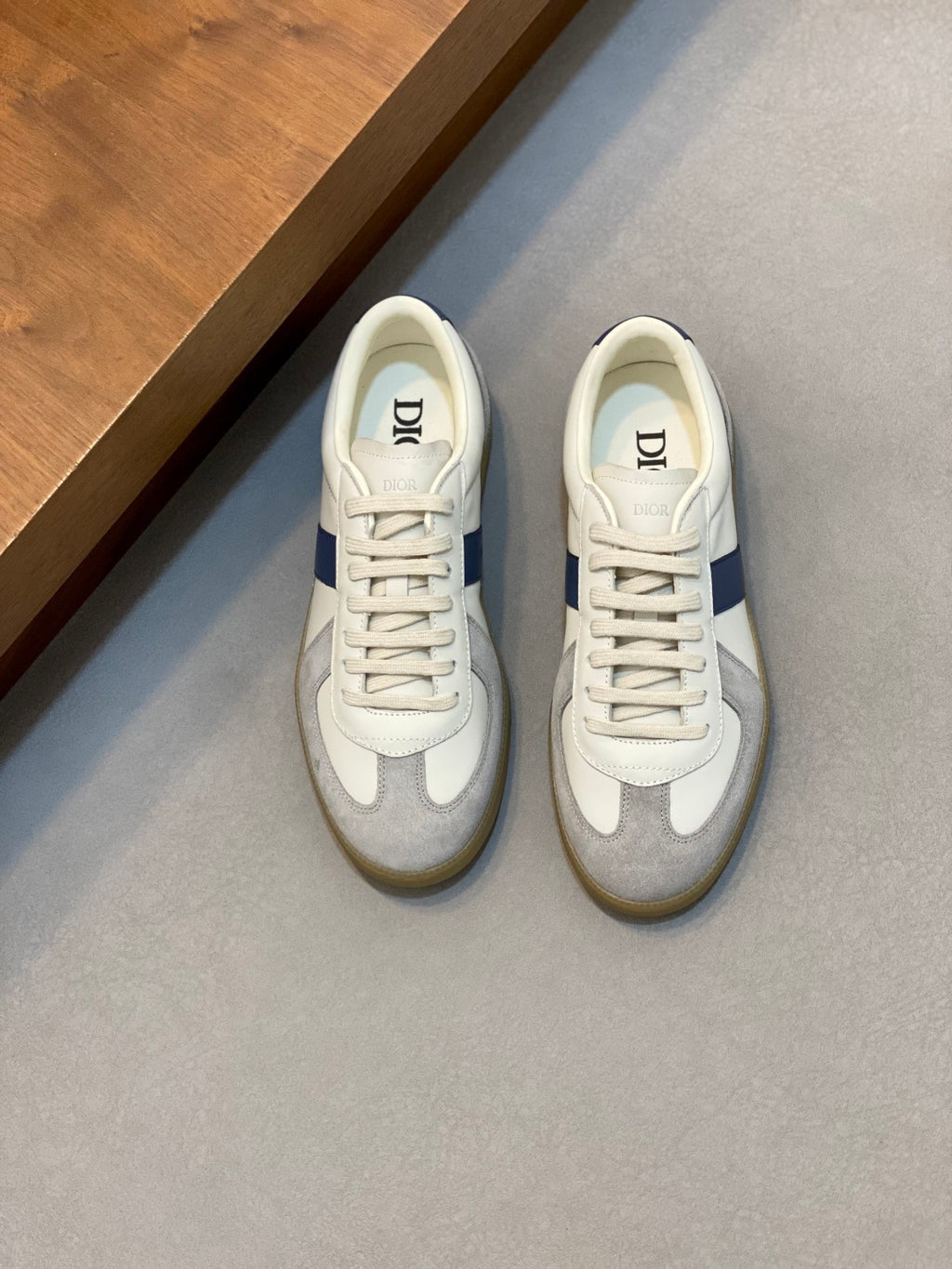 White and blue low-top sneakers with lace-up closure and rubber sole