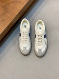 White and blue low-top sneakers with lace-up closure and rubber sole