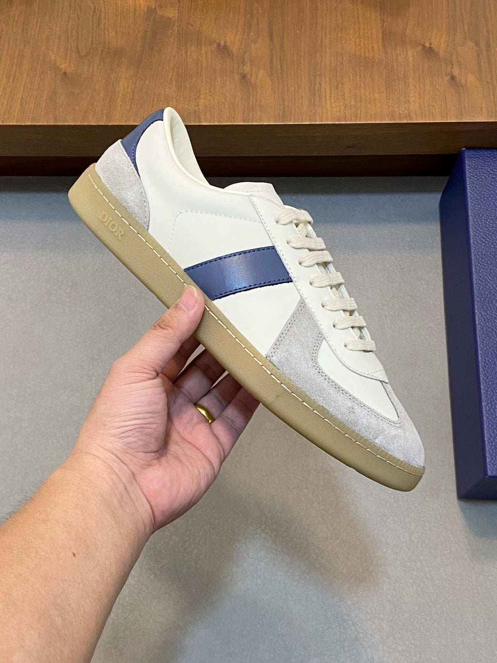 White and blue low-top sneaker with lace-up front and tan rubber sole