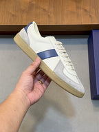 White and blue low-top sneaker with lace-up front and tan rubber sole