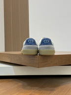 Rear view of blue low-top sneakers with light gray lining and tan rubber sole