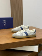 Low-top sneakers with white leather upper, blue stripe detail, and lace-up front