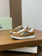 Pair of tan suede sneakers with white laces and blue check side panels
