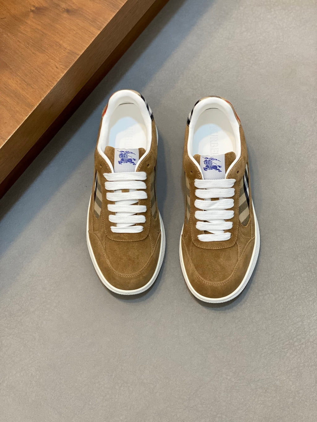 Tan suede sneakers with white laces and blue check panel detail