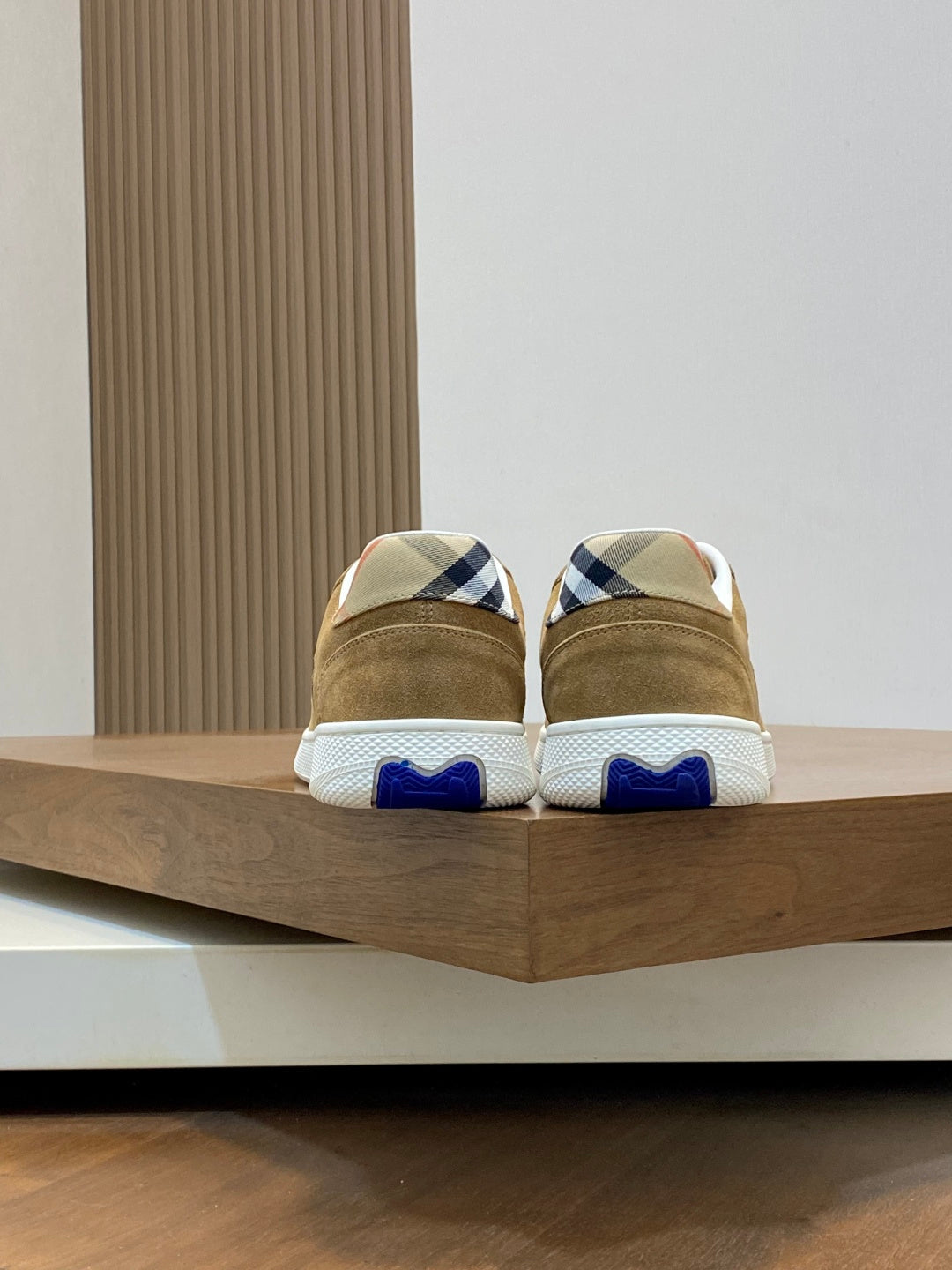 Back view of tan suede sneakers with blue-and-white plaid heel details