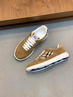 Tan suede sneakers on a display shelf with white laces and blue check detail