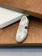 White and blue low-top sneakers with lace-up closure on a wooden display shelf
