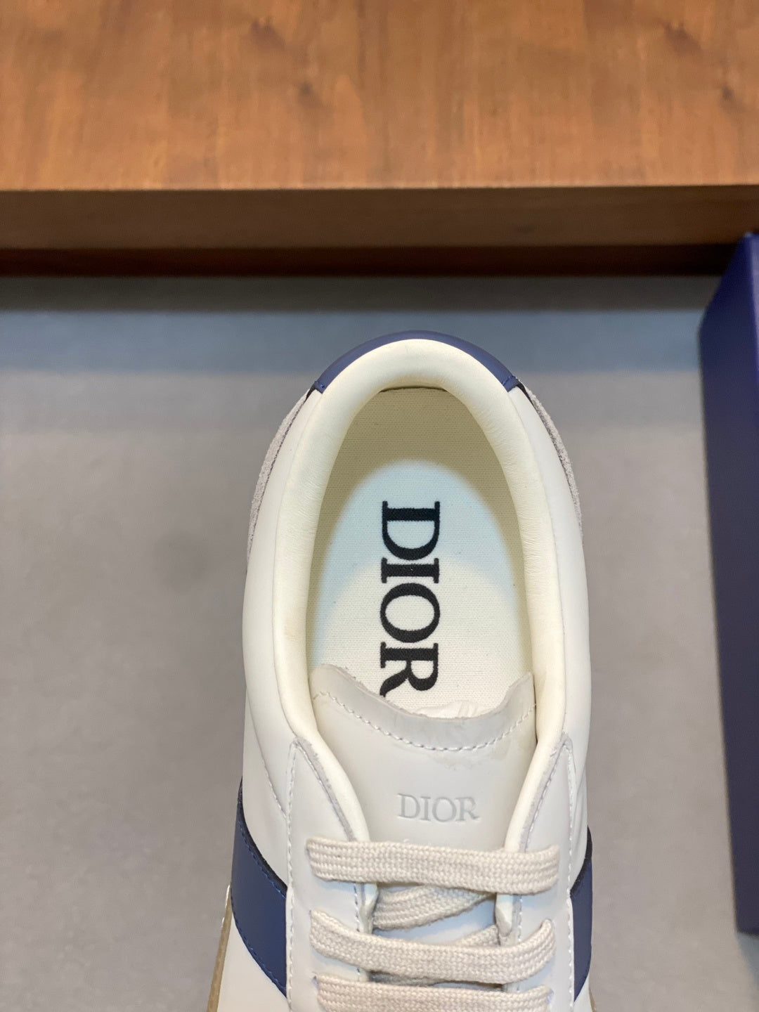 Dior low-top sneaker tongue and laces, white upper with blue side stripe