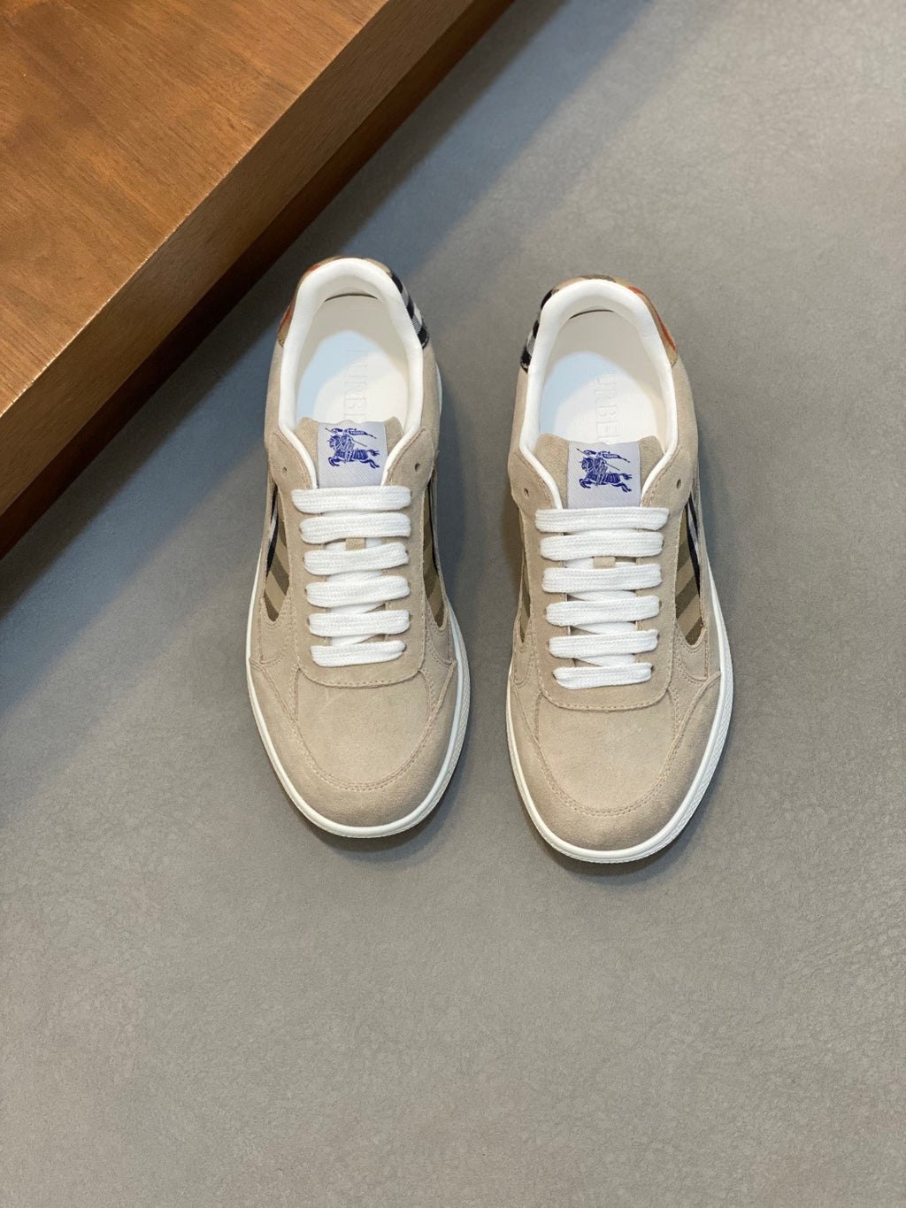 Tan suede sneakers with white laces and blue check accent