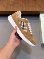 Tan suede sneaker with cutout window, blue-and-white plaid accent, white laces