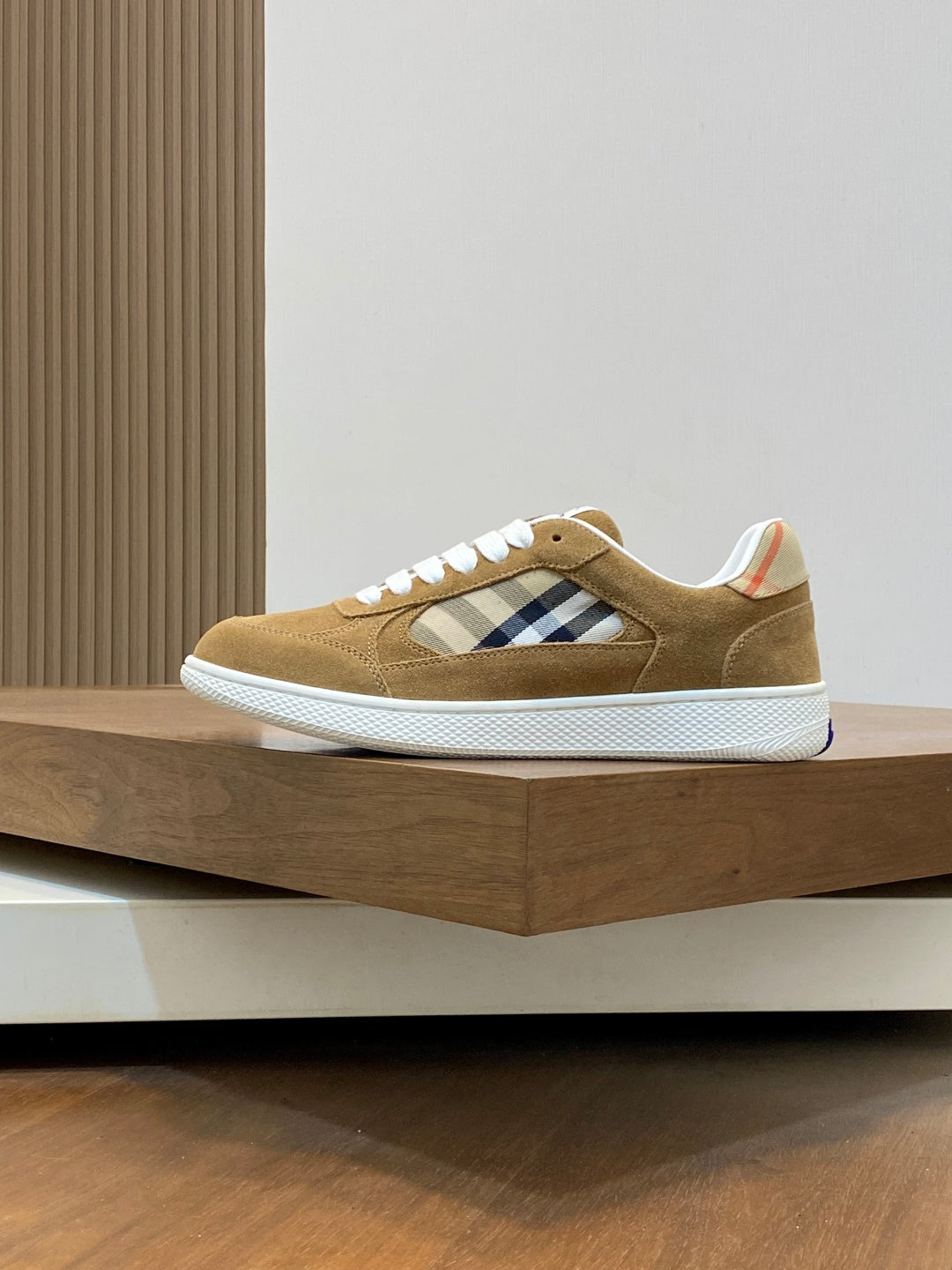 Tan suede low-top sneakers with white laces, blue plaid stripe, white sole