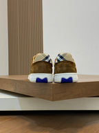 Back view of brown suede sneakers on shelf, showing blue heel detail and white sole