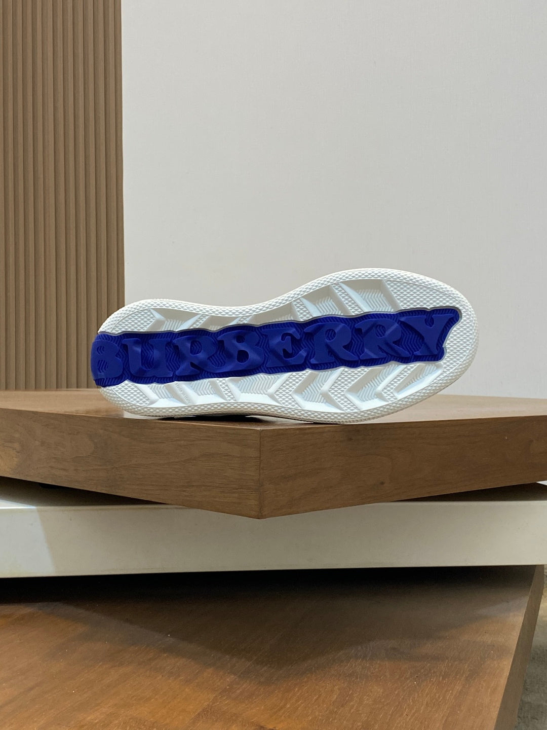 Shoe outsole/heel base with white tread and blue Burberry-style lettering detail