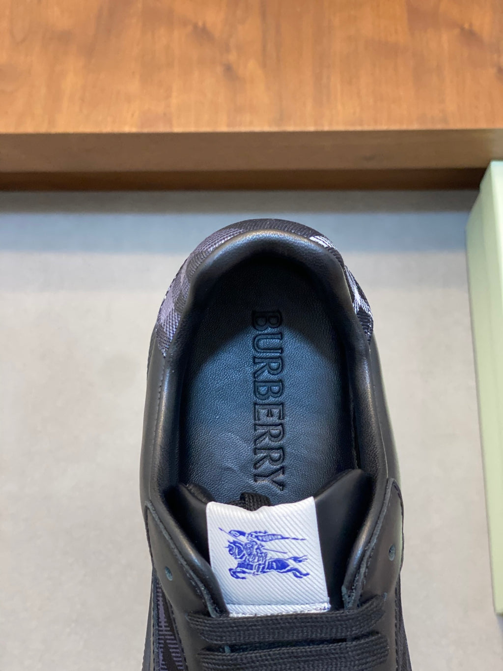 Burberry sneaker tongue patch with engraved logo and blue plaid lining