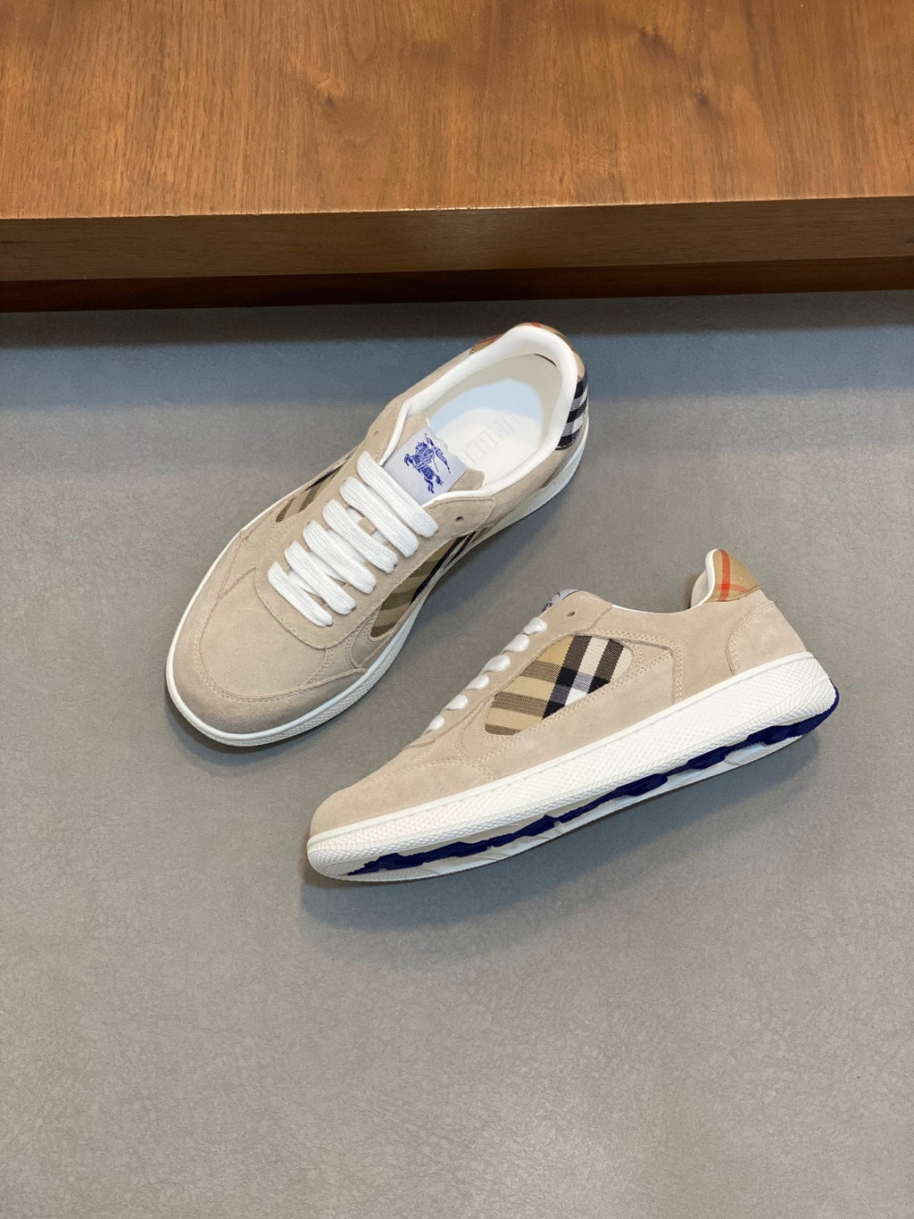 Tan and white sneakers with blue check inset and blue logo sole