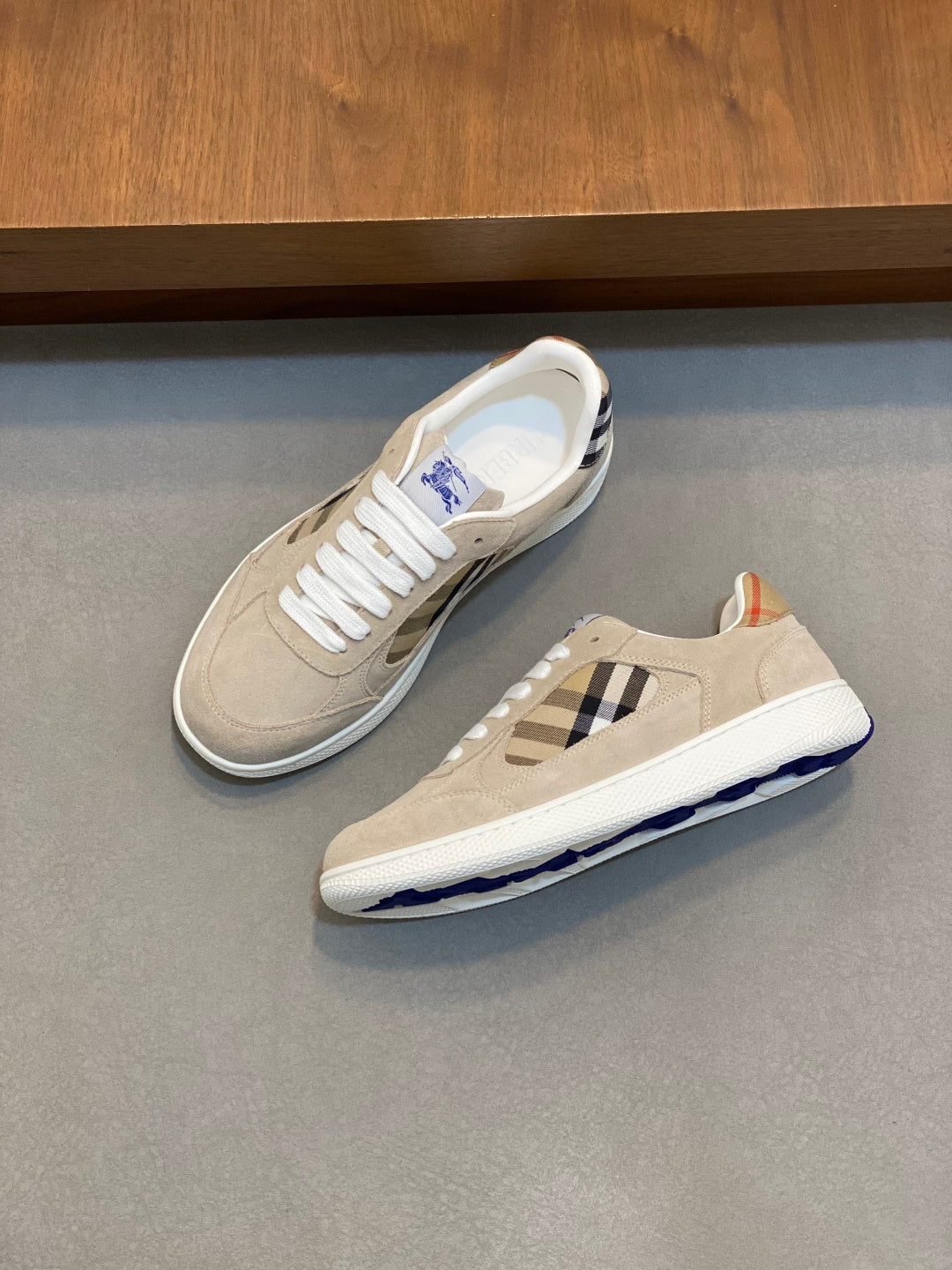 Tan and white sneakers with blue check inset and blue logo sole