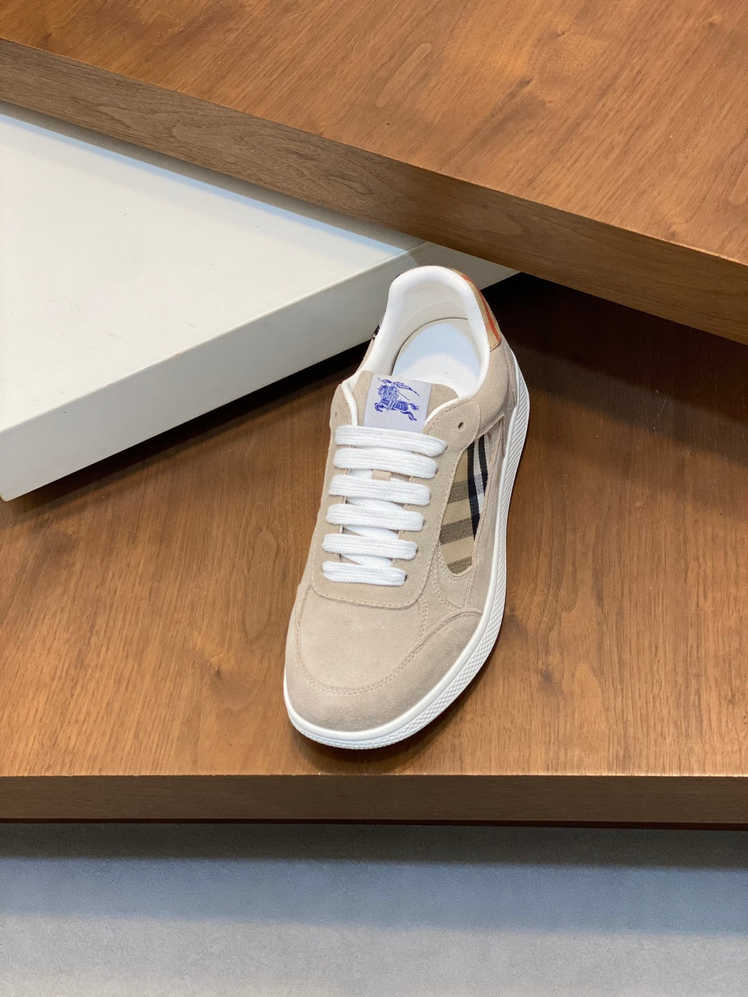 Tan suede sneaker with white laces and blue plaid side detail