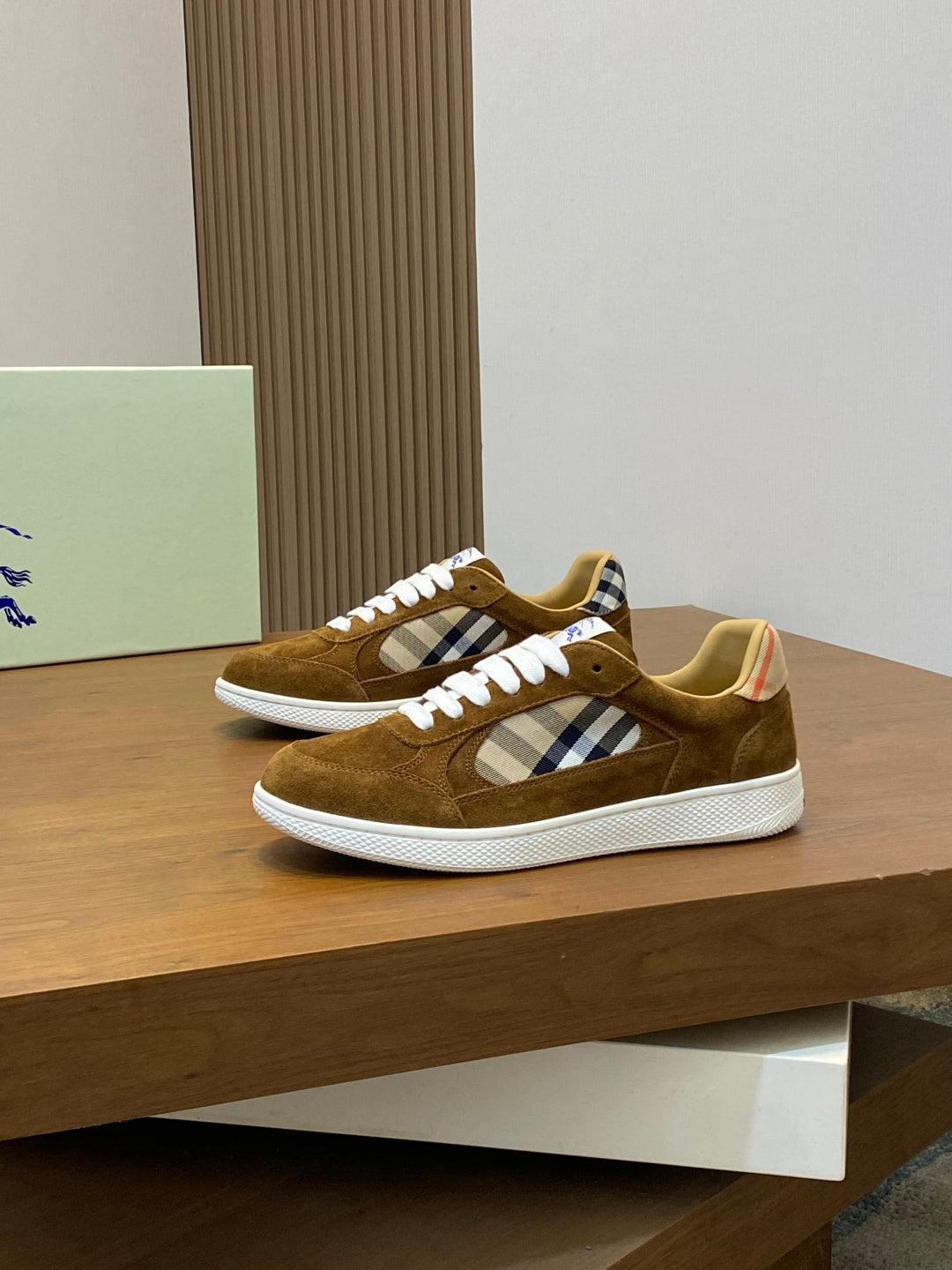 Brown suede sneakers shown from front three-quarter view with check panel and white laces