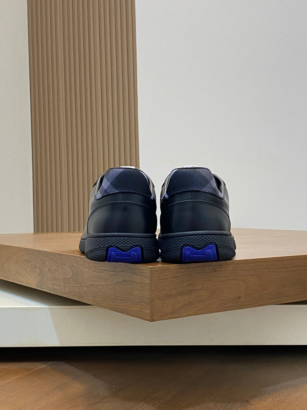 Burberry sneakers with blue heel accents, dark leather, lace-up rear view