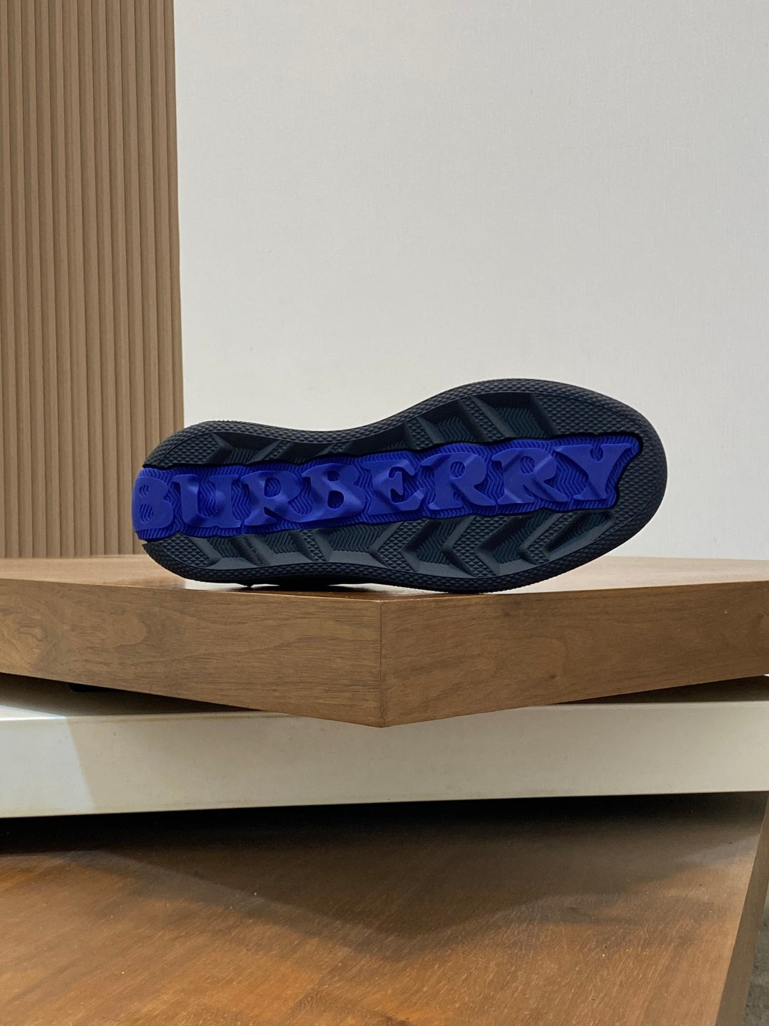 Burberry sneaker outsole with blue tread lettering, dark sole underside