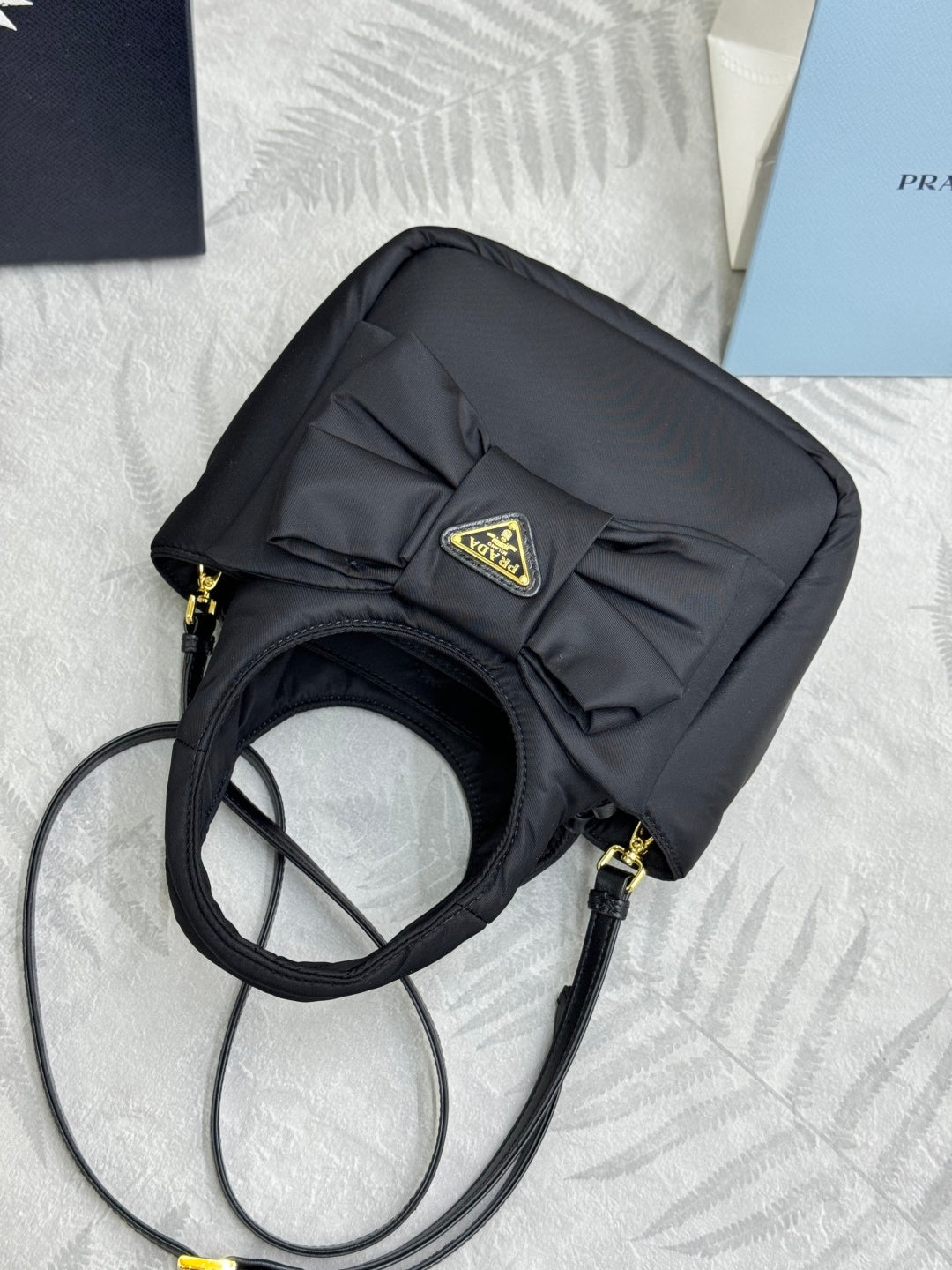 Prada black nylon mini crossbody bag with adjustable strap and gold logo badge