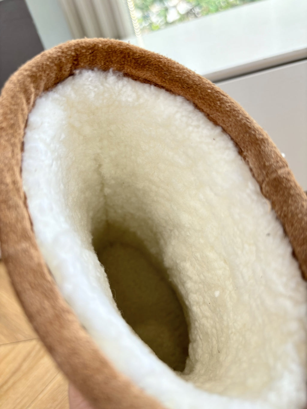 Tan boot interior with plush shearling lining and stitched opening rim